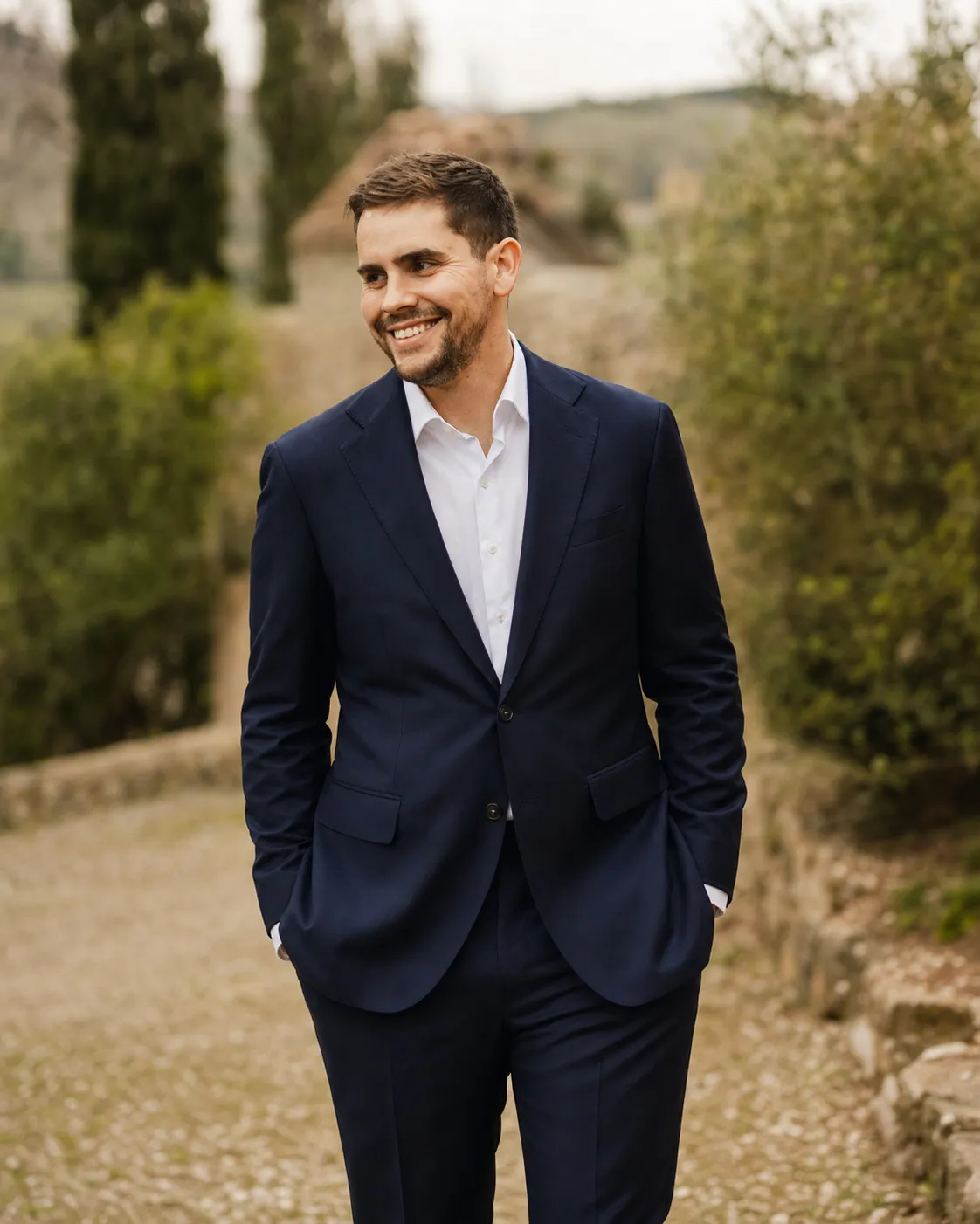 Marc Kohlmann smiling outdoors in a navy blazer and open-collar white shirt.